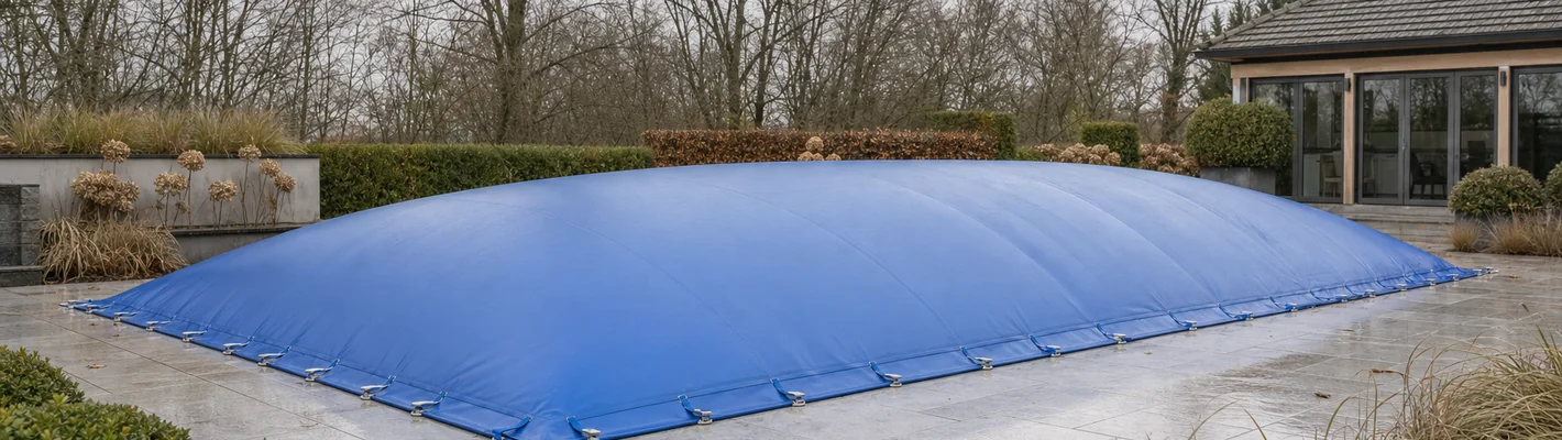 Aufblasbare Winterabdeckung auf einem privaten Schwimmbecken, konvex aufgewölbt mit umlaufender Randbefestigung