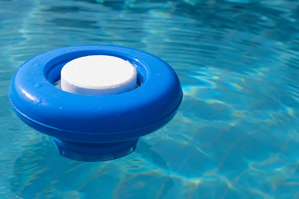 Dosierschwimmer mit Chlortablette auf der Wasseroberfläche eines Pools