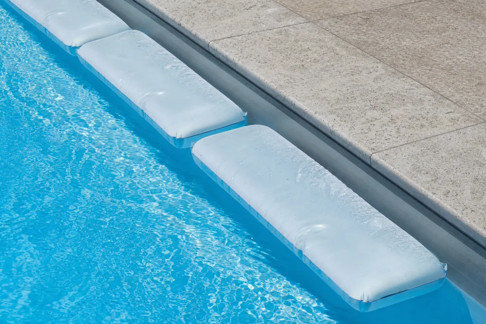 Eisdruckpolster schwimmt entlang der Beckenwand unter der Winterabdeckung