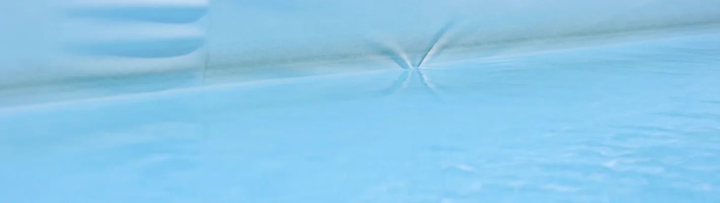 Poolfolie mit Faltenbildung an der Wand und Verfärbung an der Wasserlinie