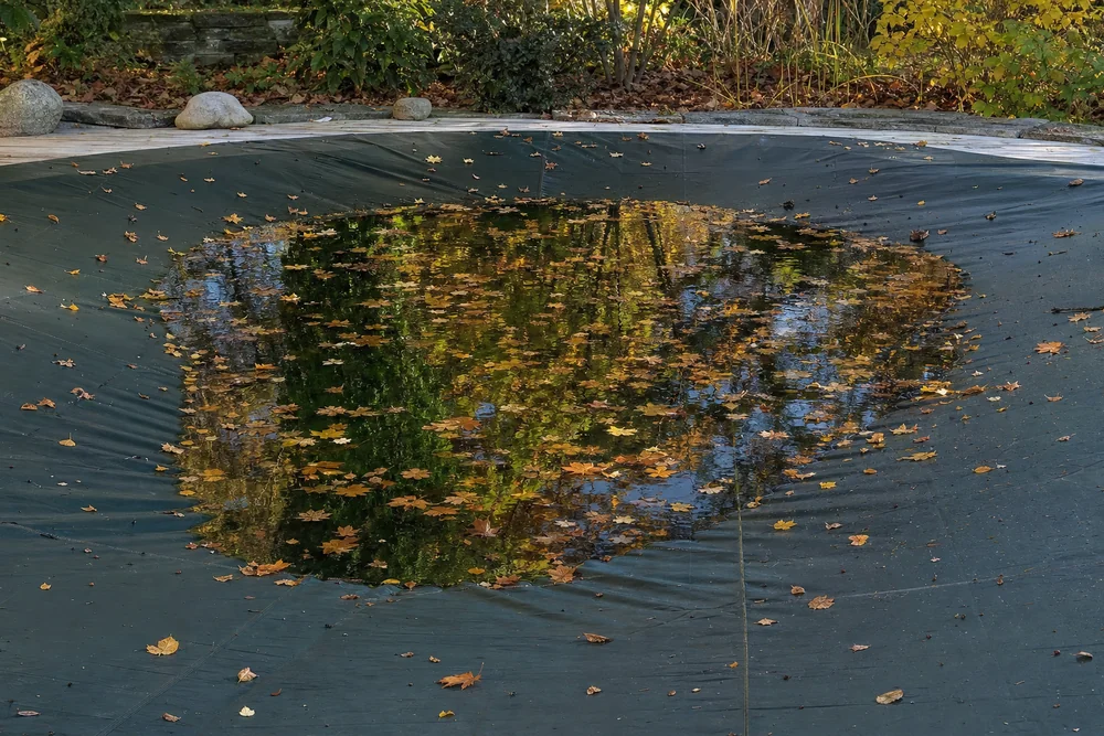 Wasserlache in der durchhängenden Mitte einer Poolabdeckplane