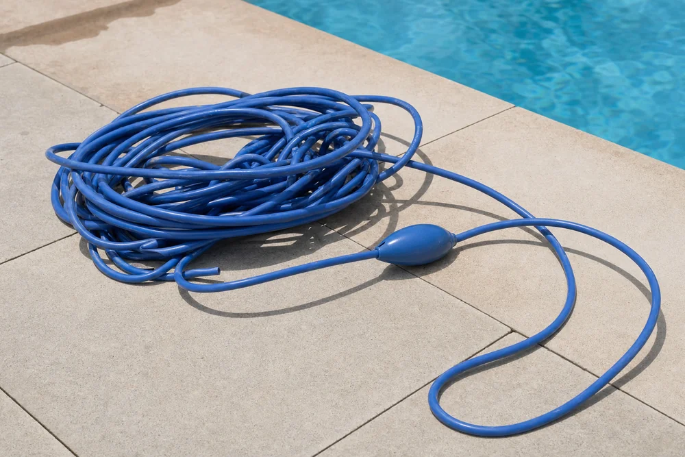 Verdrehtes Poolroboter-Kabel in Schlaufen neben dem Becken