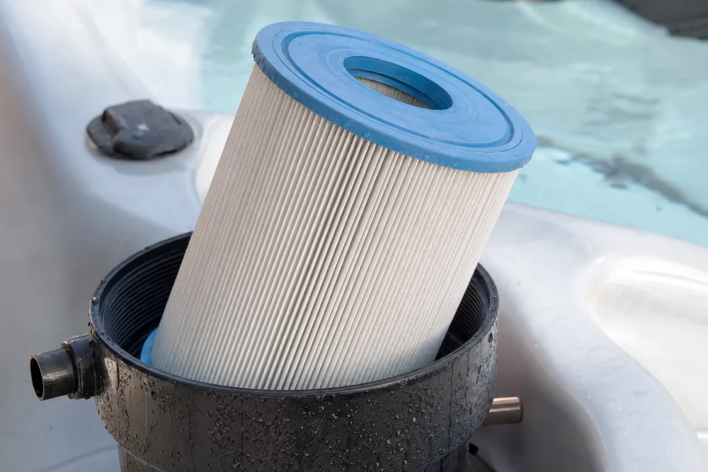 Filterkartusche eines Whirlpools wird aus dem Gehäuse gezogen