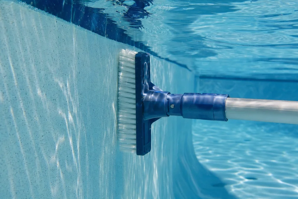 Poolbürste am Teleskopstiel reinigt die Beckenwand unter Wasser