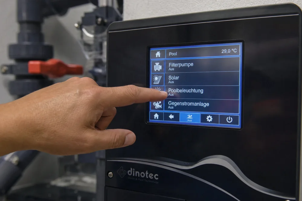 Person bedient das Touch-Display einer modernen Poolsteuerung