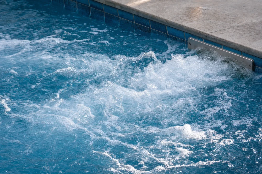 Schaumbildung im sprudelnden Wasser einer Gegenstromanlage am Pool