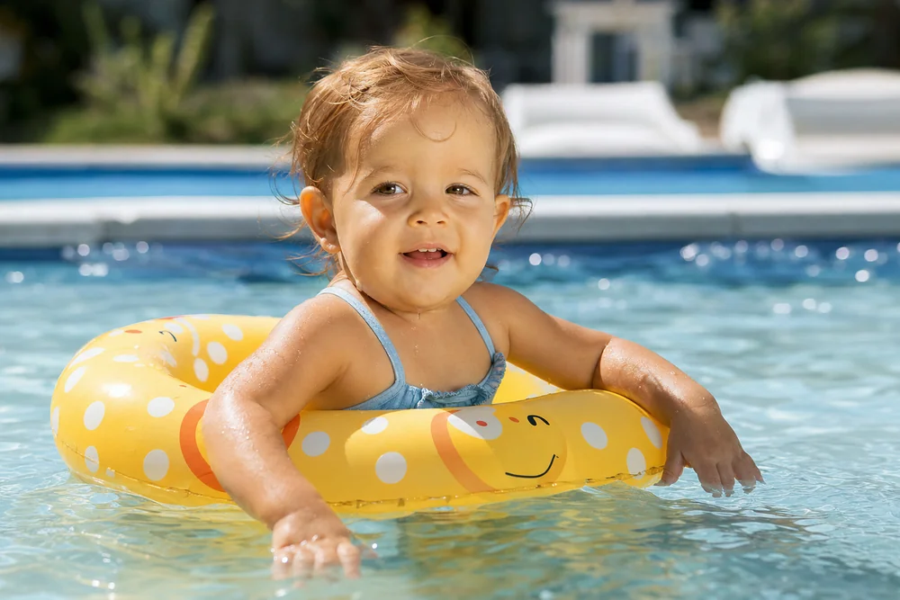 Kind mit passendem Schwimmring im flachen Poolwasser