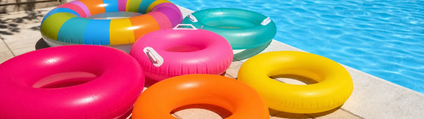 Bunte Schwimmringe in verschiedenen Größen am Pool