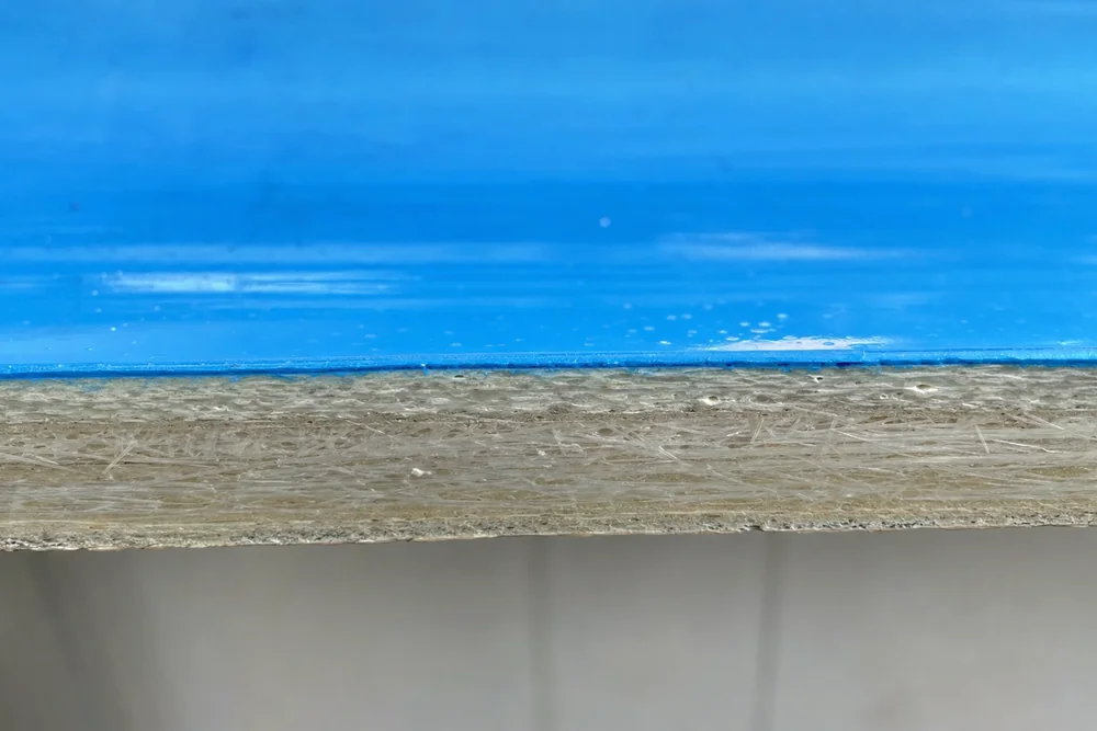Schichtaufbau einer GFK-Beckenwand mit Gelcoat und Laminat im Querschnitt