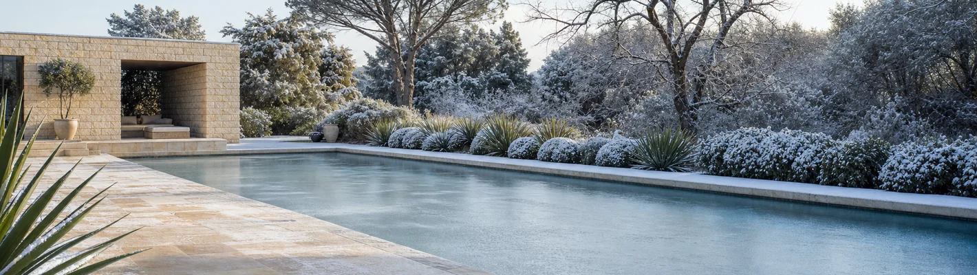 Winterlich abgedecktes Schwimmbecken mit Schnee und teilweiser Eisdecke
