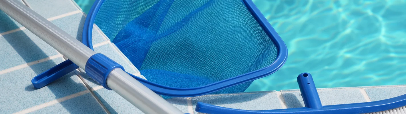 Zubehör zur Schwimmbadreinigung: Teleskopstange, Kescher und Bürste am Beckenrand