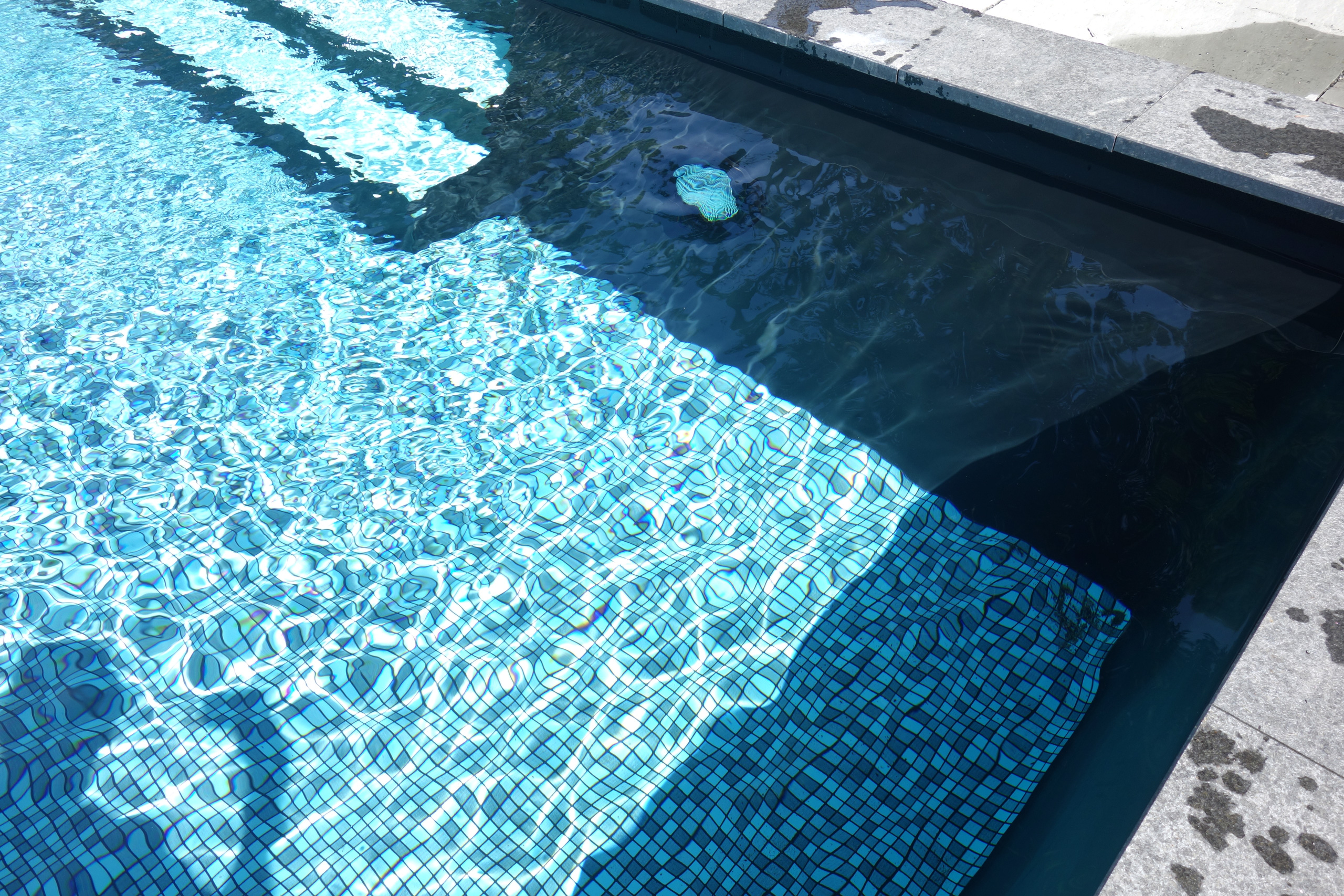 Detailansicht des rechteckigen Pools mit gerader Treppe und blauem Mosaikmuster im Becken