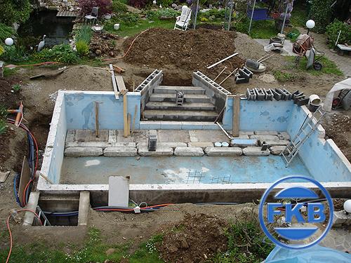 Baustelle eines Pools mit gemauerter Treppe und hellblauer Grundierung vor der Beckensanierung