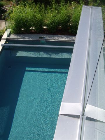 Blick von oben auf ein Schwimmbecken mit Granit-Optik und einer Poolabdeckung