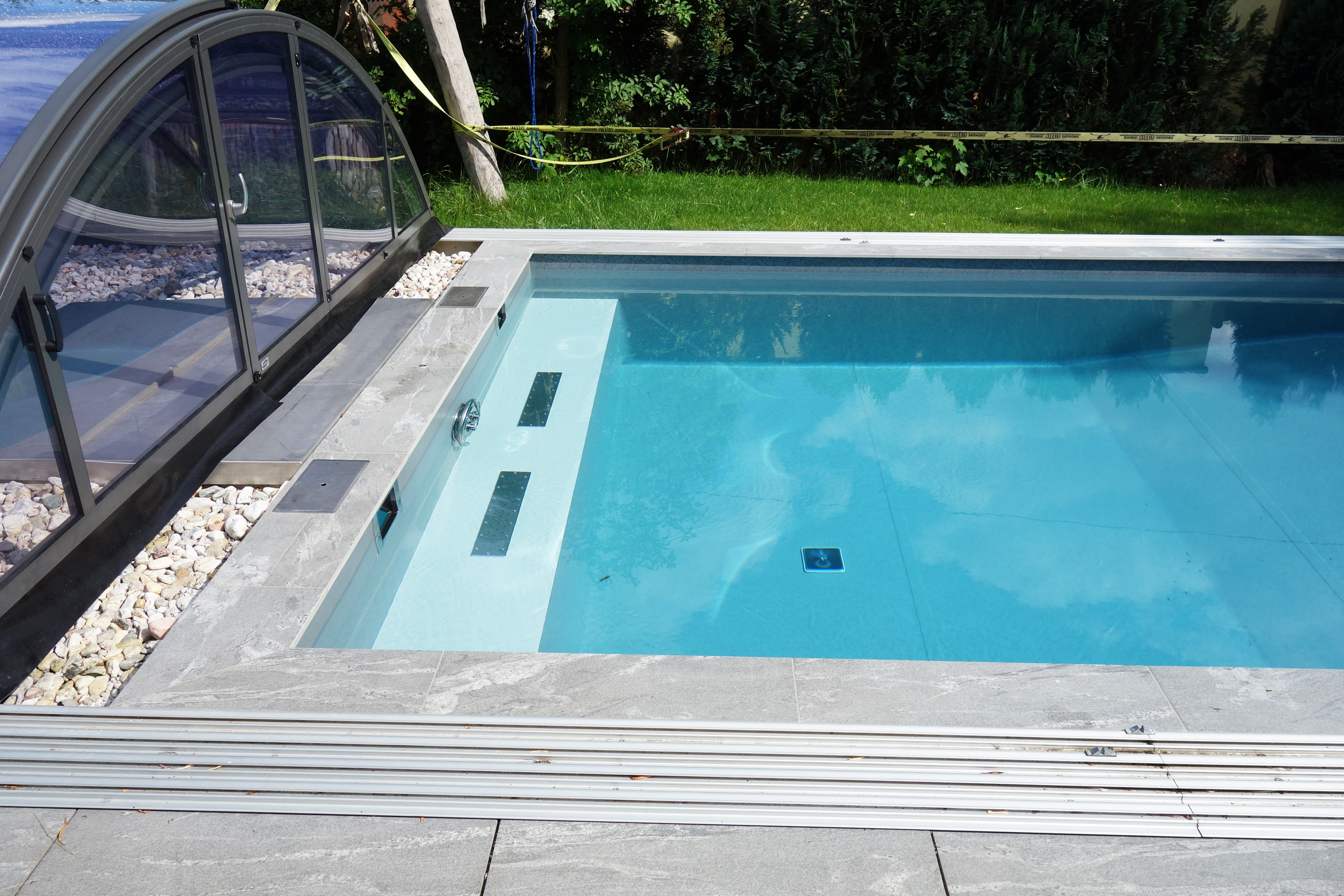 Schwimmbecken mit Ecktreppe, Podest, Überdachung und Rollladenabdeckung