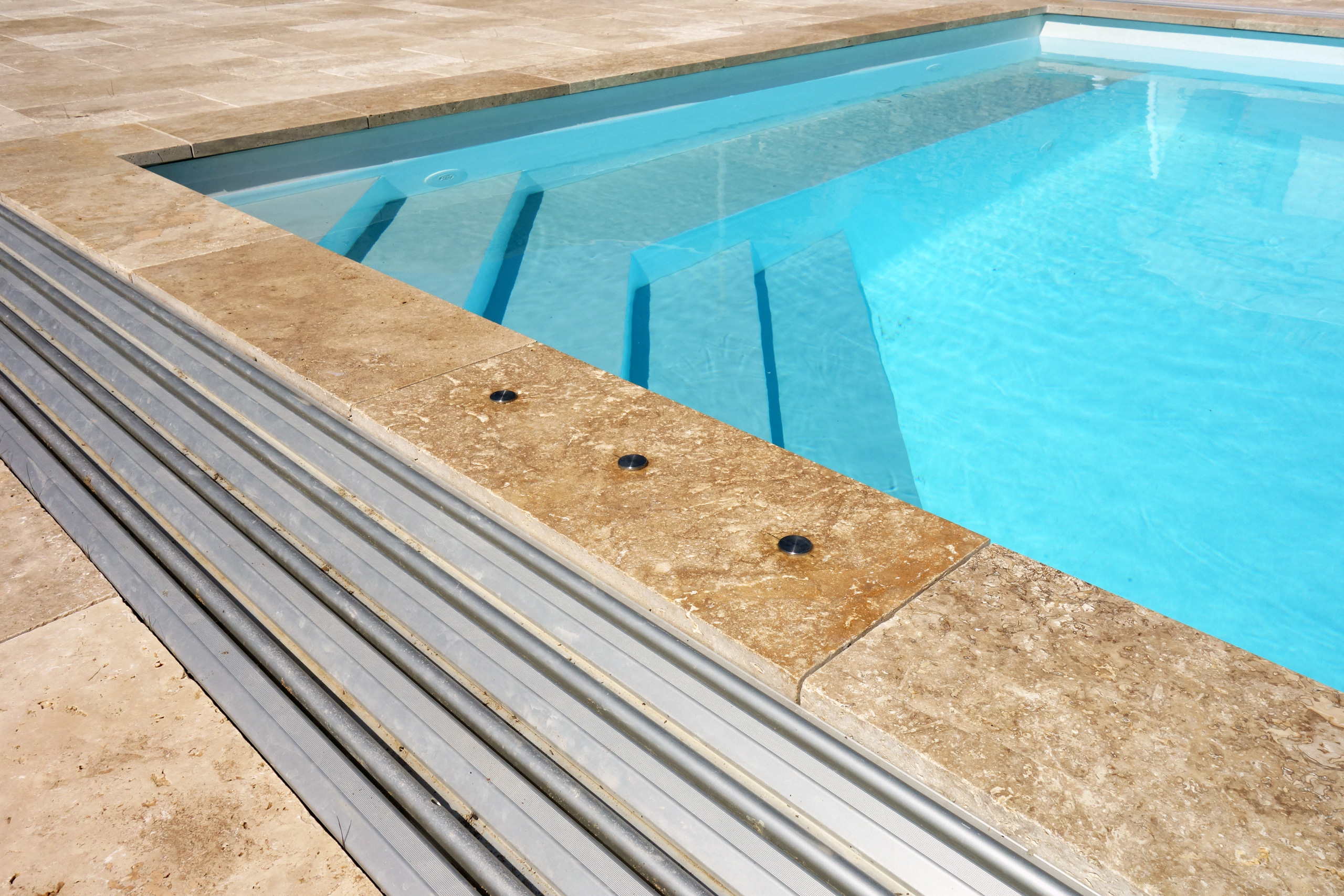 Detailansicht des Schwimmbeckens mit Rollladenabdeckung und Natursteinumrandung