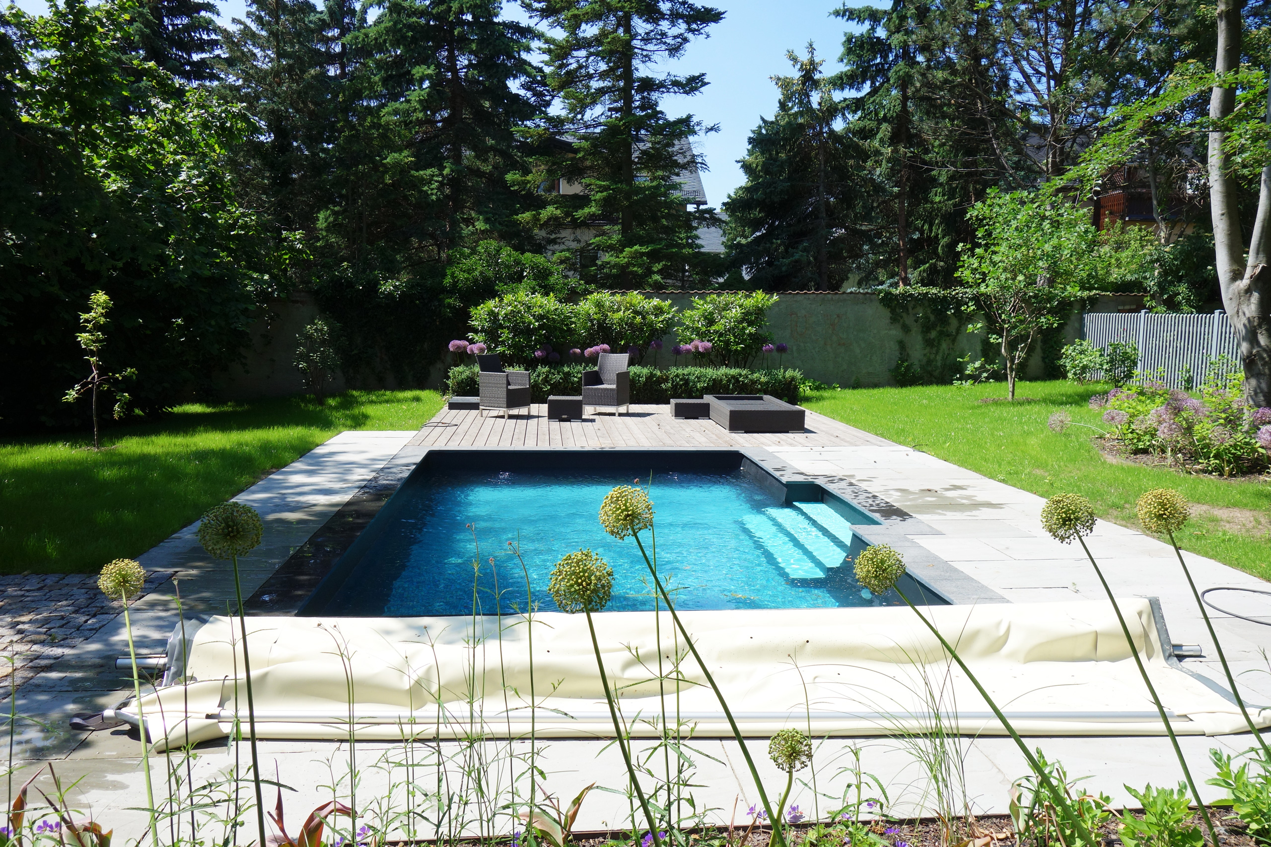 Rechteck-Pool 3,5x6x1,15m mit gerader Treppe, umgeben von Holz- und Steinplatten im Garten