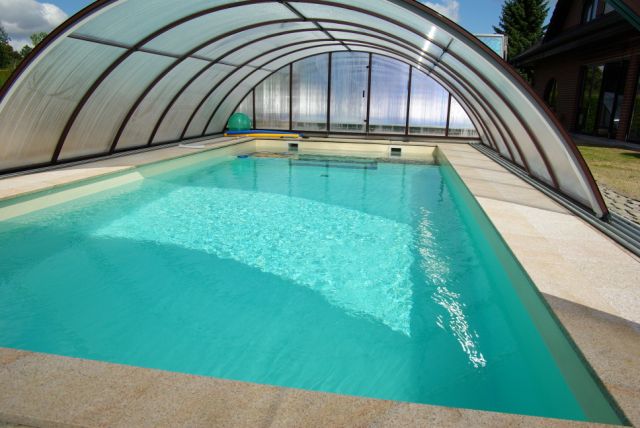 Schwimmbecken 10x4x1,5m mit innenliegender Treppe und Podest unter transparenter Poolüberdachung