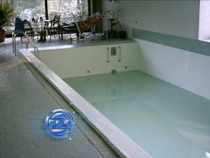 Hallenbad mit weißer Einhängefolie und Treppe, Blick auf die Wasseroberfläche und den Beckenrand