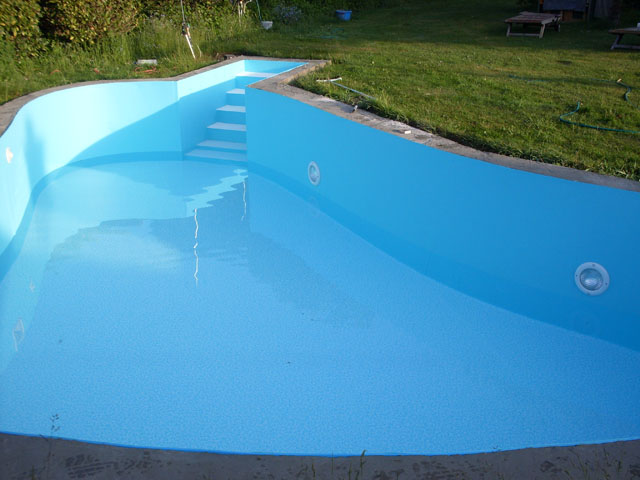 Freiformbecken mit blauer Folie und weißer Treppe, teilweise mit Wasser gefüllt, im Garten