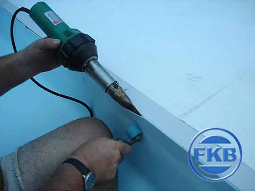 Verlegung und Verschweißung der hellblauen Beckensanierungsfolie mit Heißluftgerät und Andrückrolle