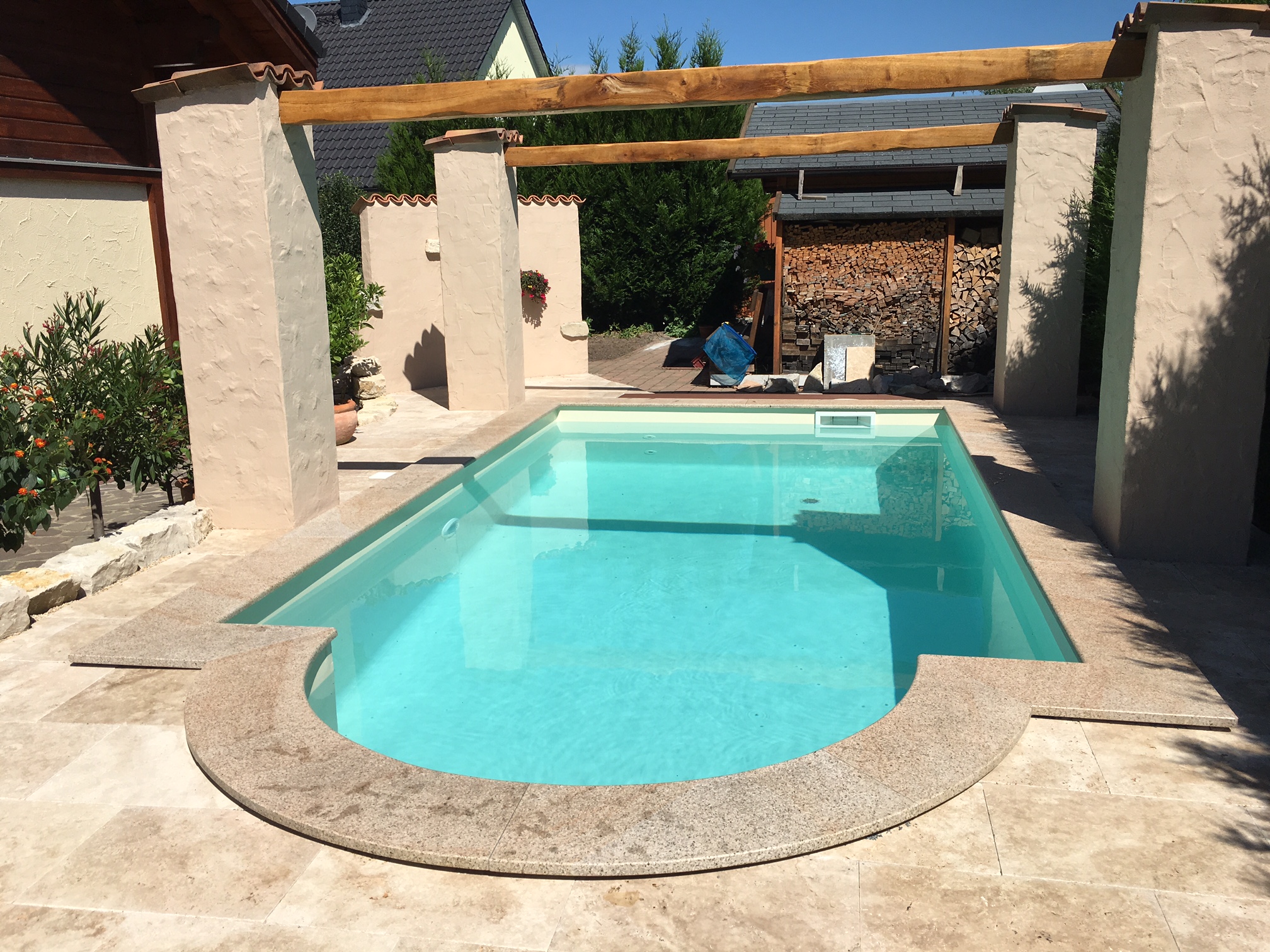 Schwimmbecken 3x5x1,50m mit römischer Treppe im Garten, umgeben von beigefarbenen Fliesen