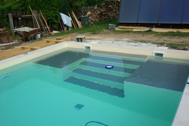 Blick auf die innenliegende Treppe und das Podest eines Schwimmbeckens während der Befüllung.