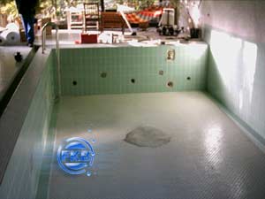 Leeres Hallenbad mit alten grünen Fliesen und vorbereitetem Untergrund für die Sanierung mit weißer Folie