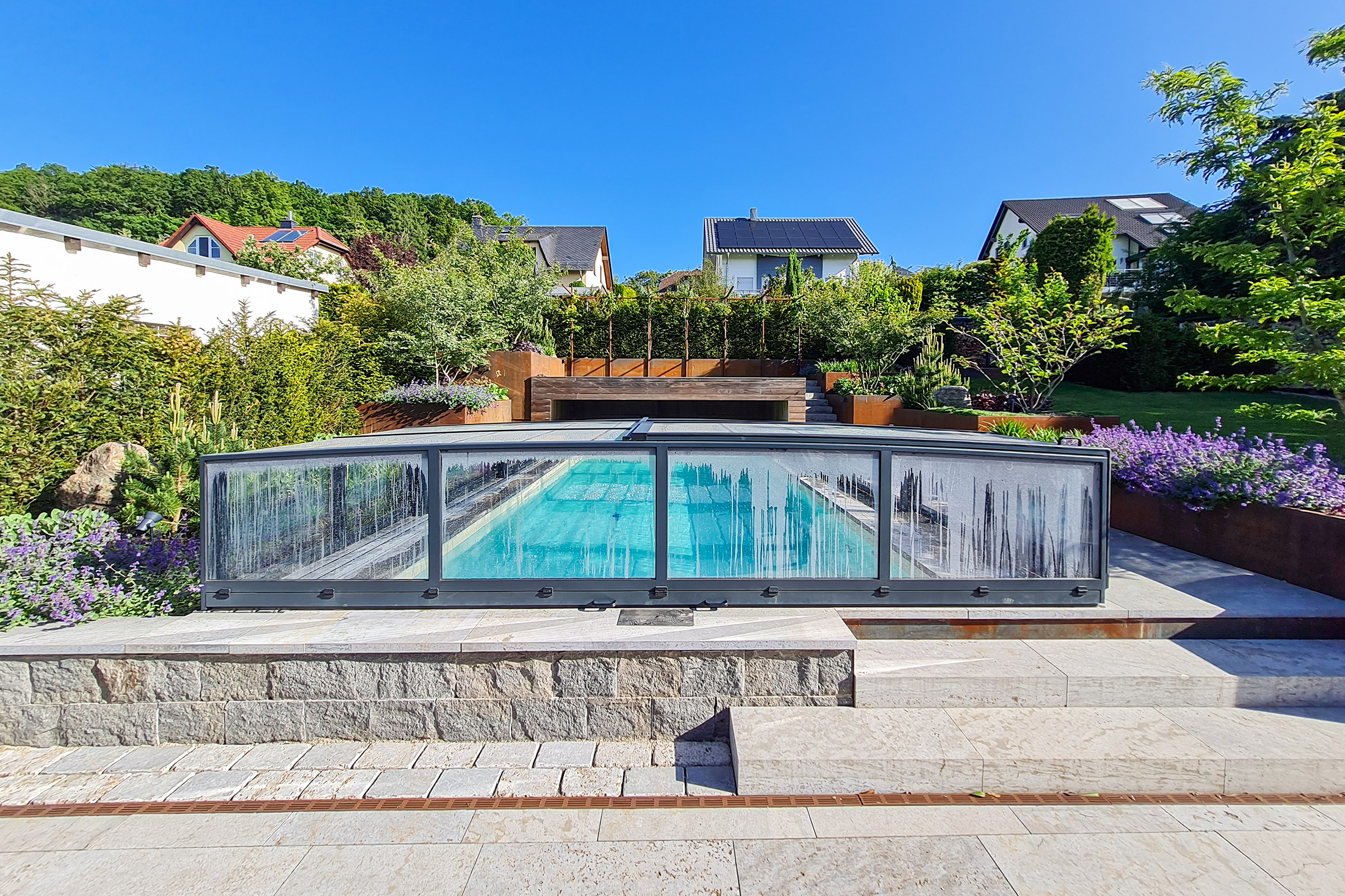 Überdachter Betonpool mit stimmiger Gartengestaltung Blick auf Massivpool mit Poolüberdachung und harmonisch eingebundener Gartengestaltung