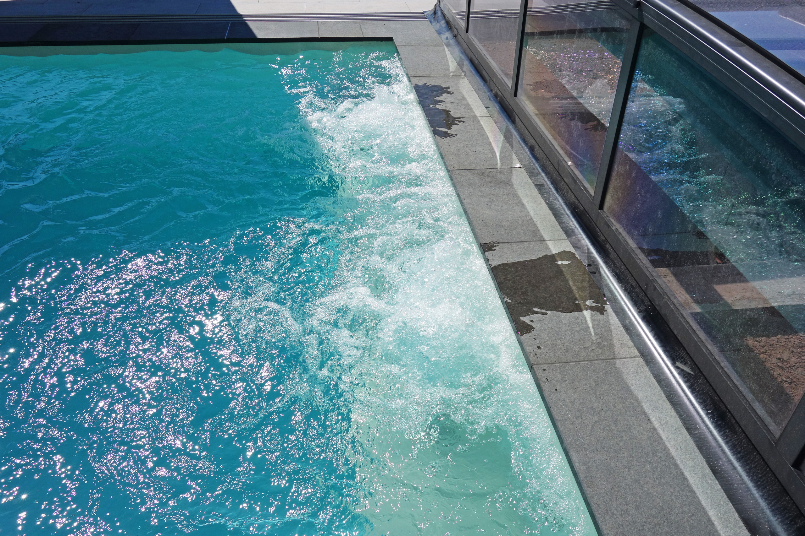 Sprudelndes Wasser der Gegenstromanlage in einem Rechteck-Schwimmbad mit Edelstahl-Einbauteilen.