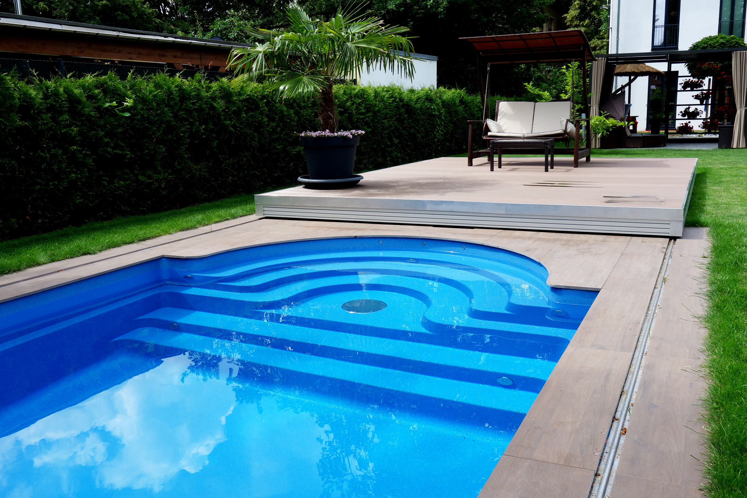 Blaues Compass Pool Schwimmbecken Java 101 mit Terrassenabdeckung und Sitzgelegenheit im Garten