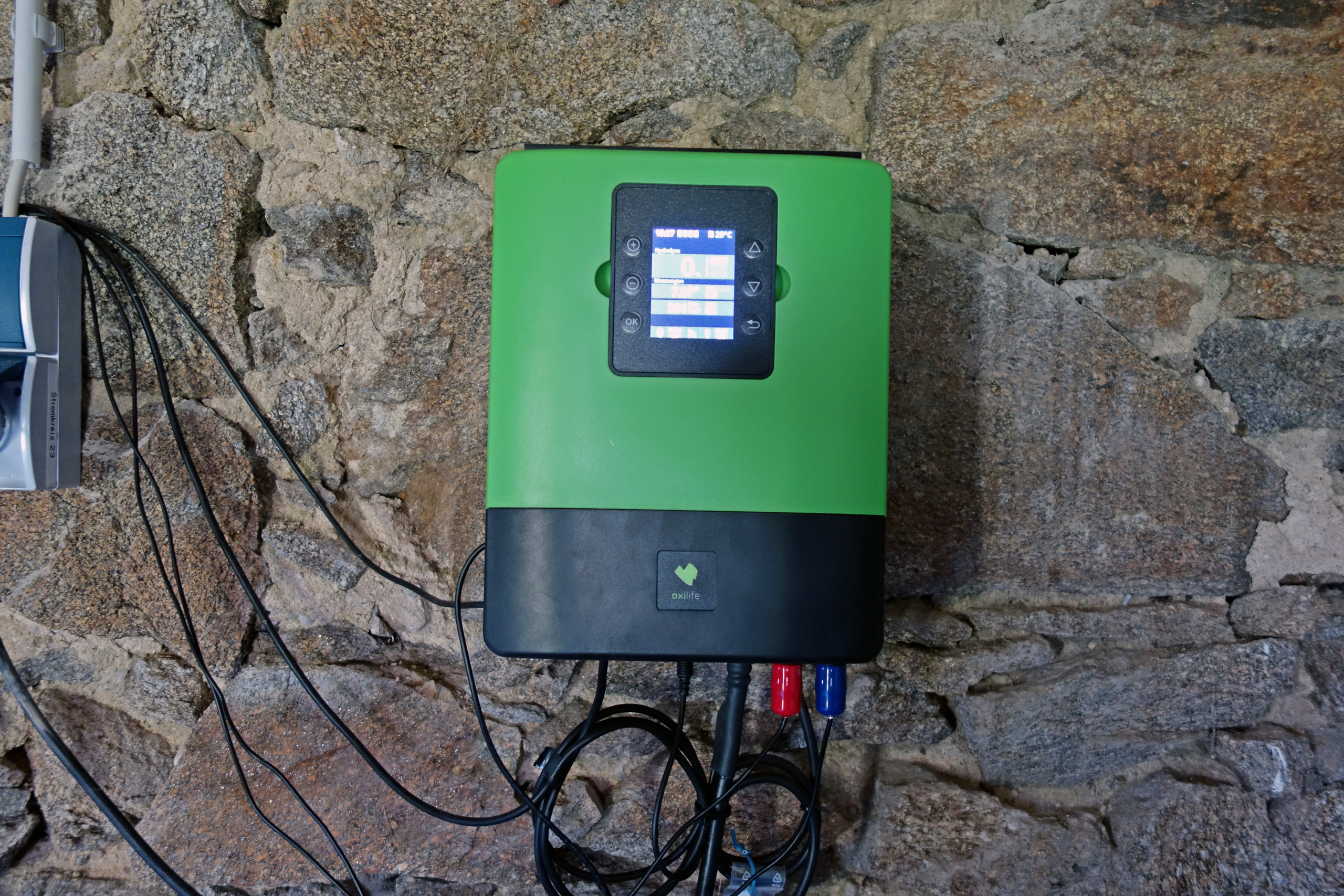 Hydrolysesystem mit Display und Kabelanschlüssen, montiert an einer Natursteinwand