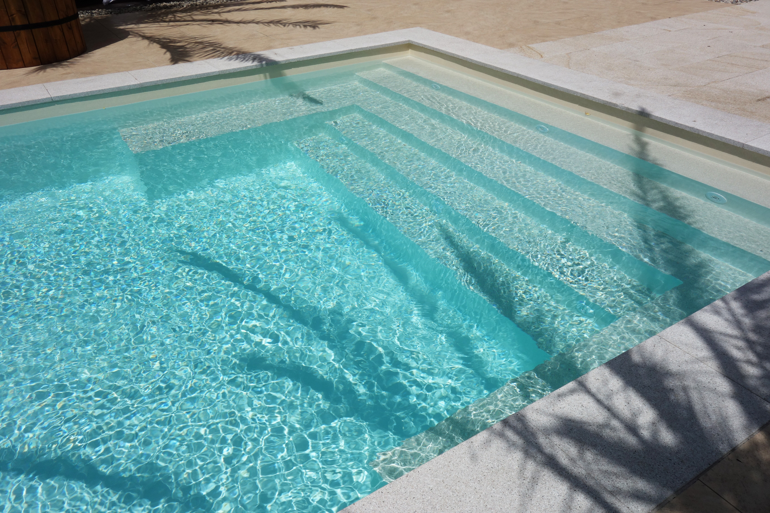 Gerade Treppe und Podest im Schwimmbad mit hellblauer Folie und klarem Wasser