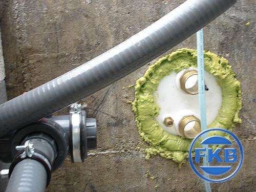 Rohrleitungen und Einbauteil mit Dämmung in einer Beckenwand, FKB Logo unten rechts
