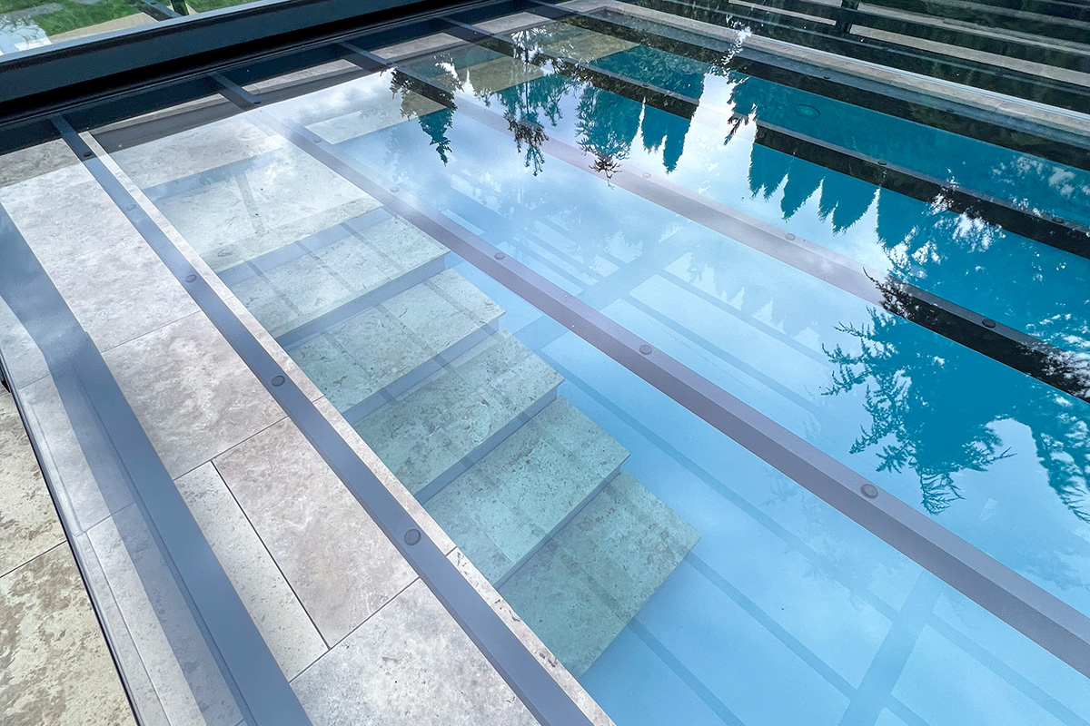 Detailansicht der Poolüberdachung Aluna Exclusive Line R1 mit transparenten Segmenten und Pooltreppe