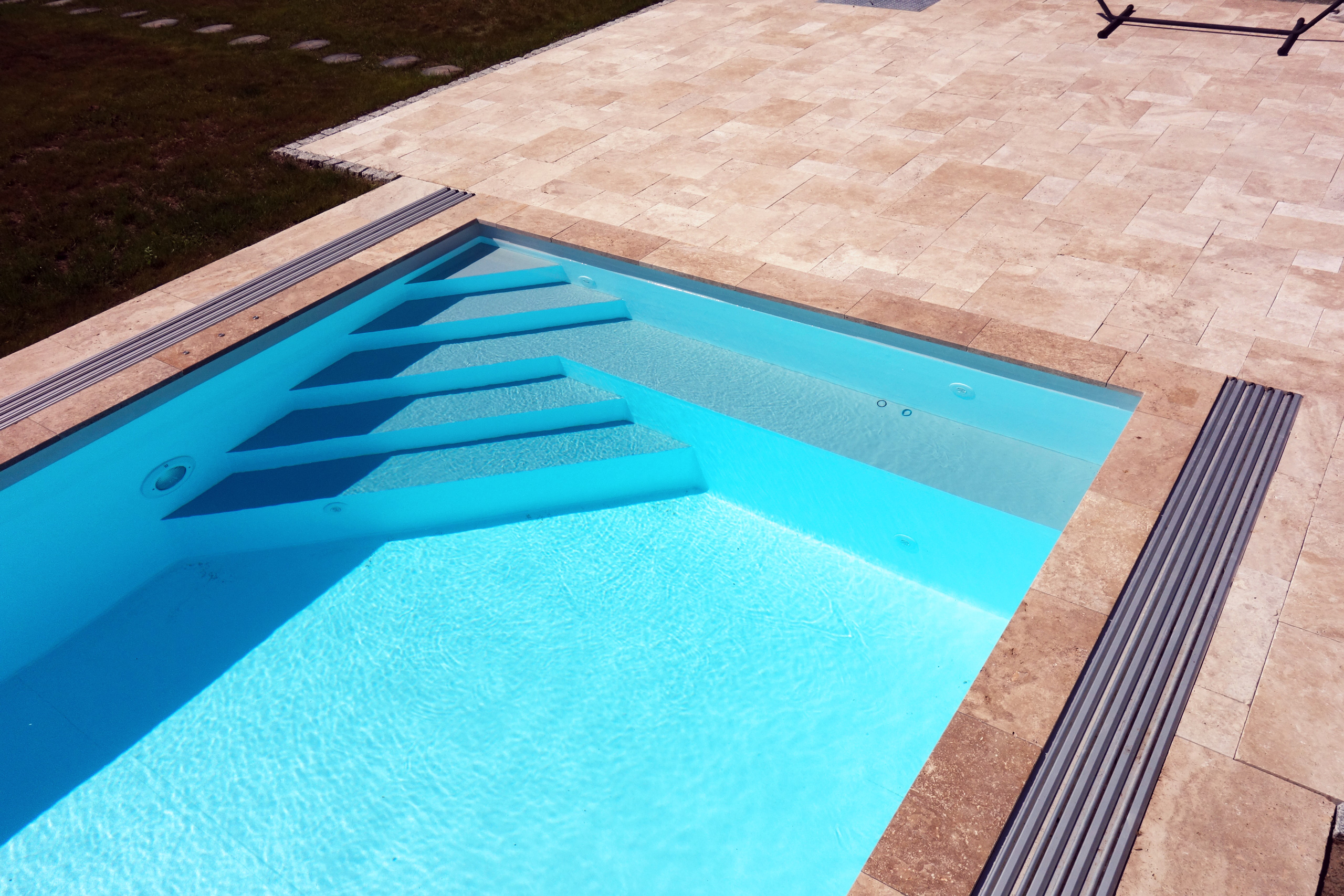 Detailansicht des Schwimmbeckens mit integrierter Treppe, Sitzbank und Poolabdeckung