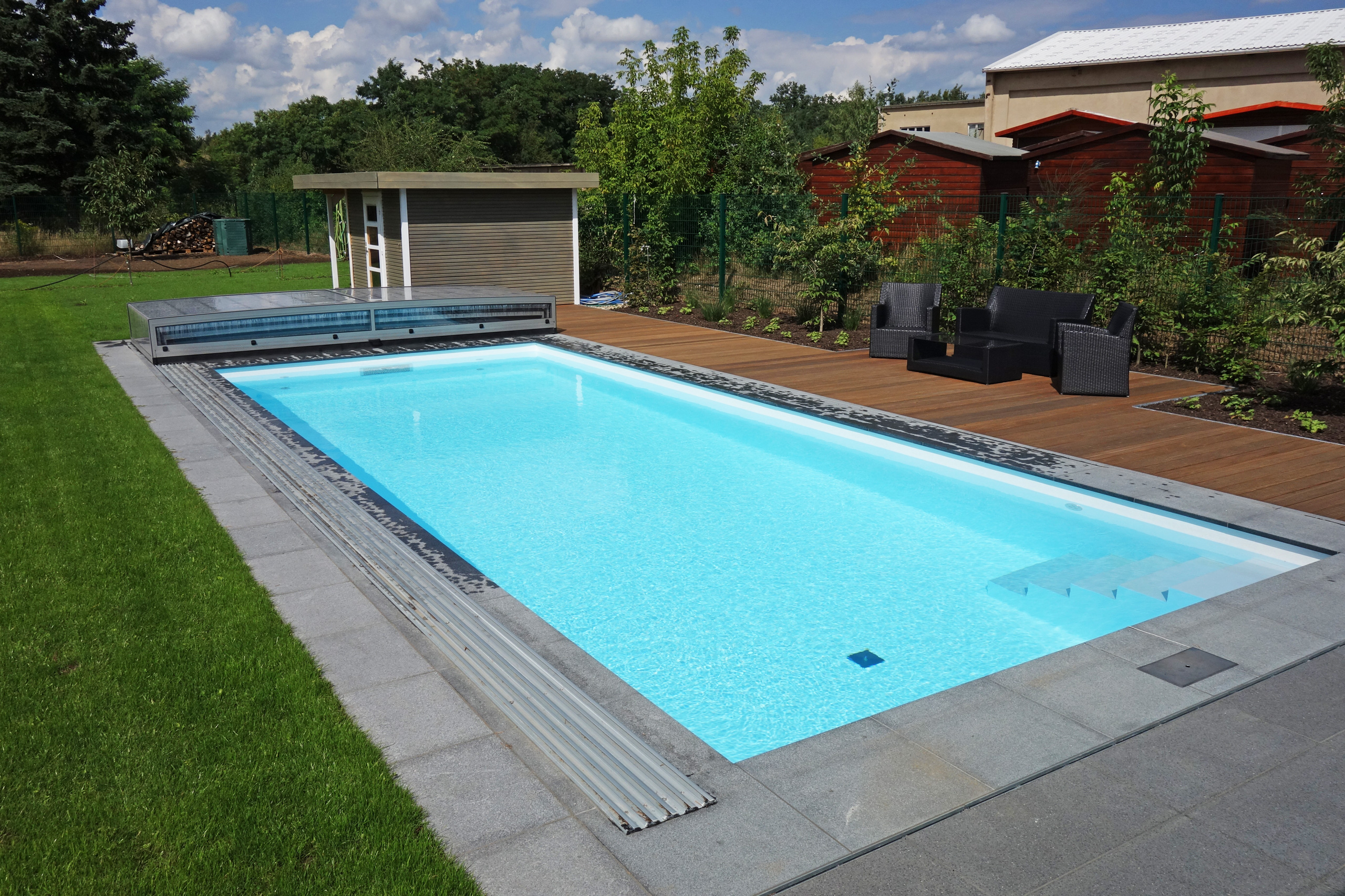 Außenpool mit gerader Treppe, Strömungsturbine und teilweiser Überdachung Horizont, umgeben von Holzterrasse