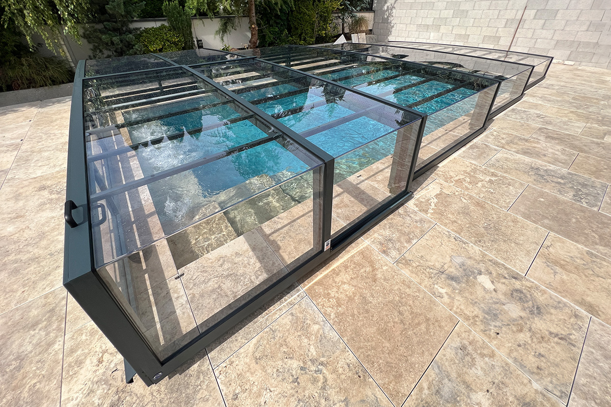 Detailansicht der flachen Poolüberdachung Aluna® Exclusive Line R1 mit transparenten Segmenten und dunklem Rahmen