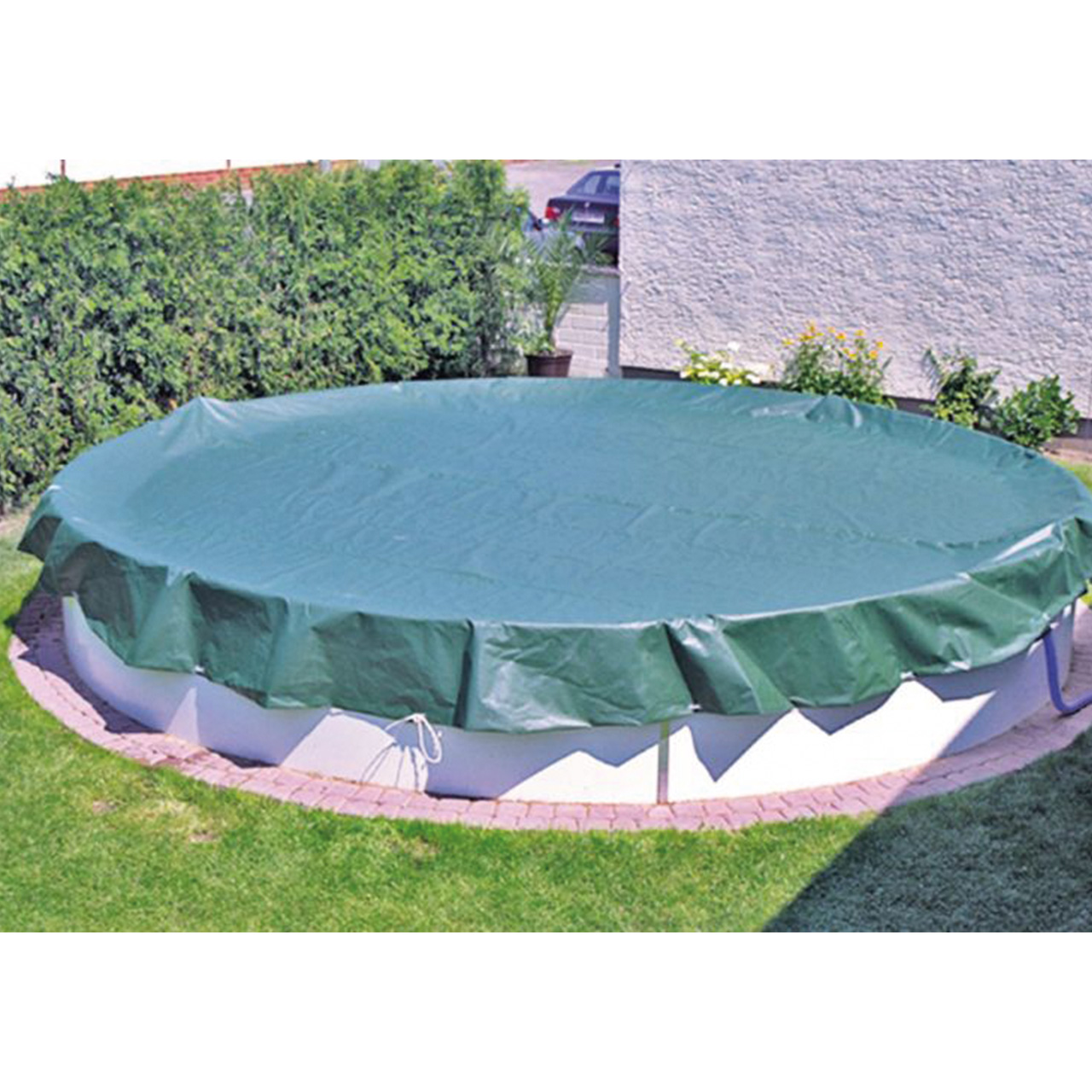 Grüne Abdeckplane auf einem runden Aufstellbecken im Garten, mit umlaufendem Spannseil.