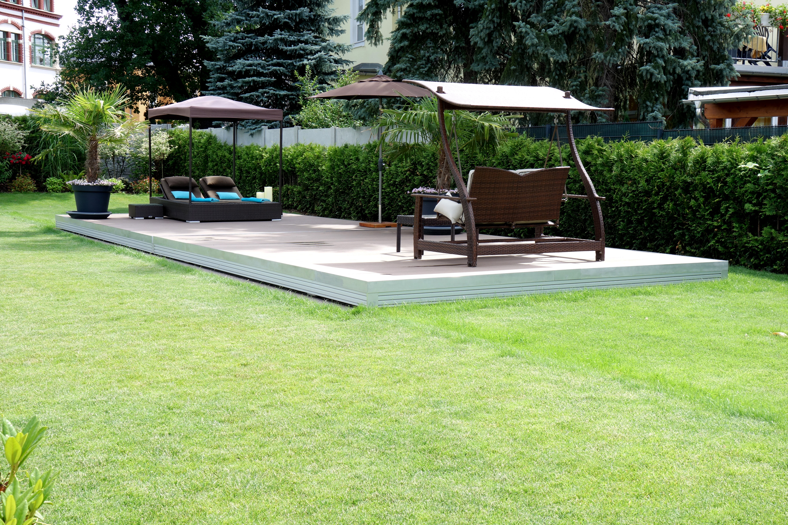 Terrassenabdeckung des Compass Pool Schwimmbeckens Java 101 mit Lounge-Möbeln im Garten