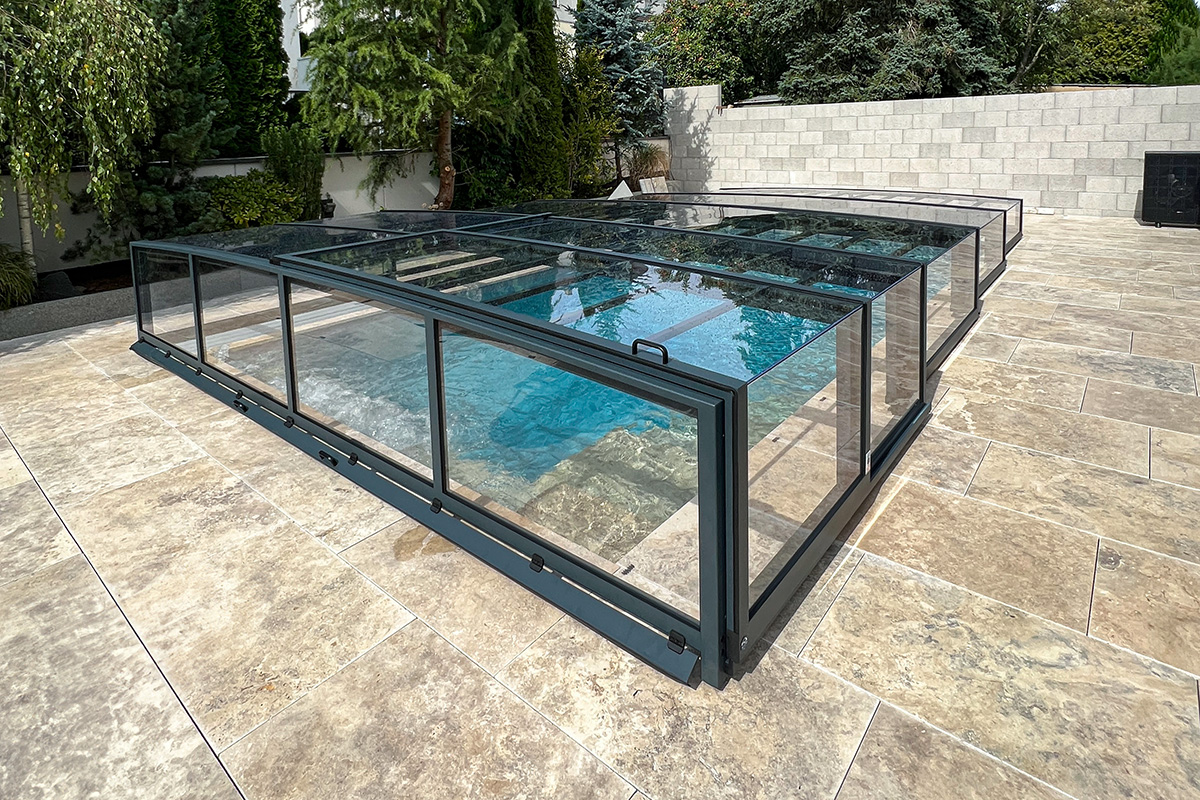 Detailansicht der flachen Poolüberdachung Aluna Exclusive Line R1 mit Schiebeelementen und transparenter Verglasung.