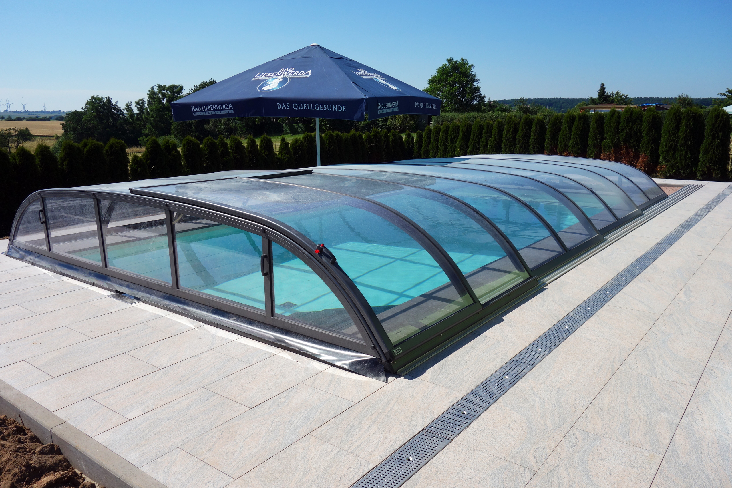 Rechteck-Schwimmbad 4x8x1,5m mit Schiebeüberdachung und umlaufender Entwässerungsrinne.