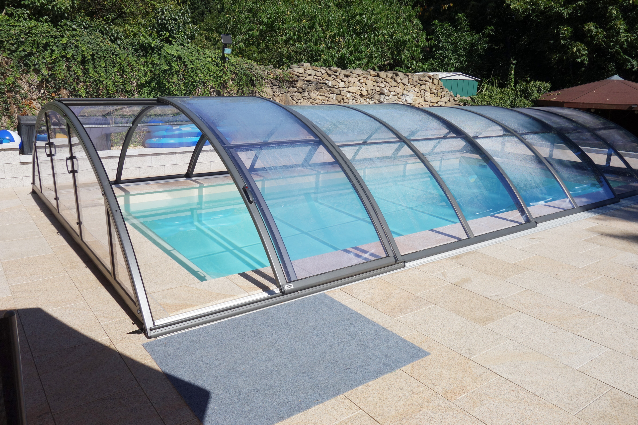 Rechteckpool 3,5x7x1,5m mit Ecktreppe, Podest, Stehstufe und Überdachung Klasik Clear in Gartenumgebung