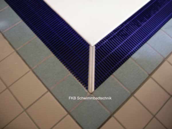 Ecke einer Schwimmbeckensanierung mit blauer Überlaufrinne und hellen Fliesen am Beckenrand
