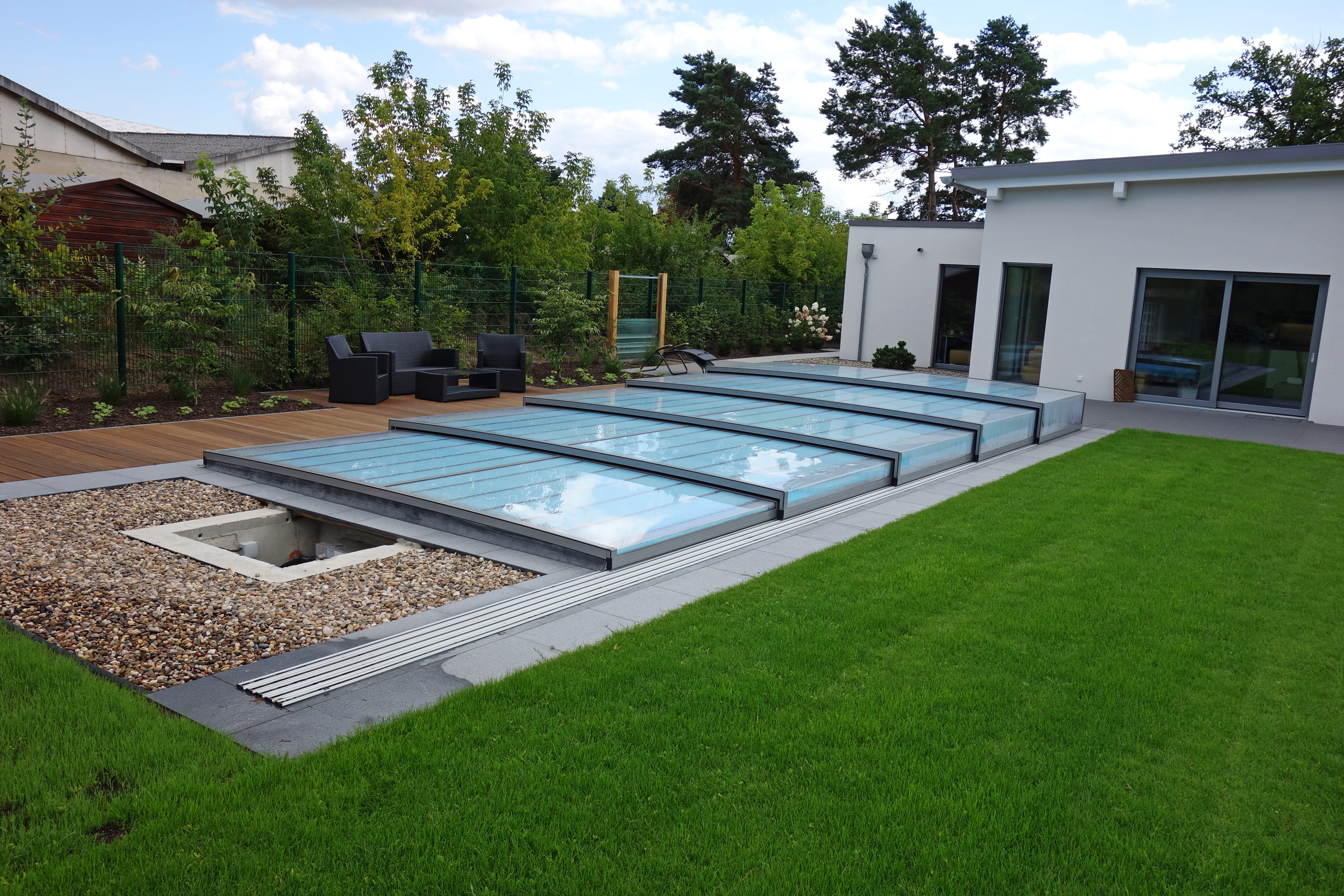Poolüberdachung Horizont auf Schienen, mit Technikschacht und Holzterrasse im Garten