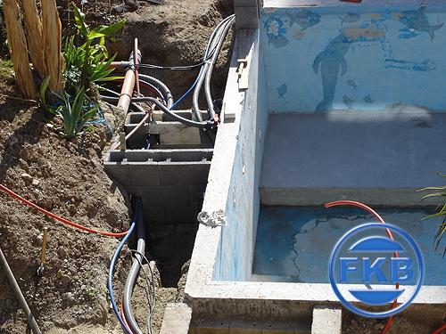 Baustelle mit freigelegten Leitungen und einem leeren Becken, bereit für die Beckensanierung in Hellblau