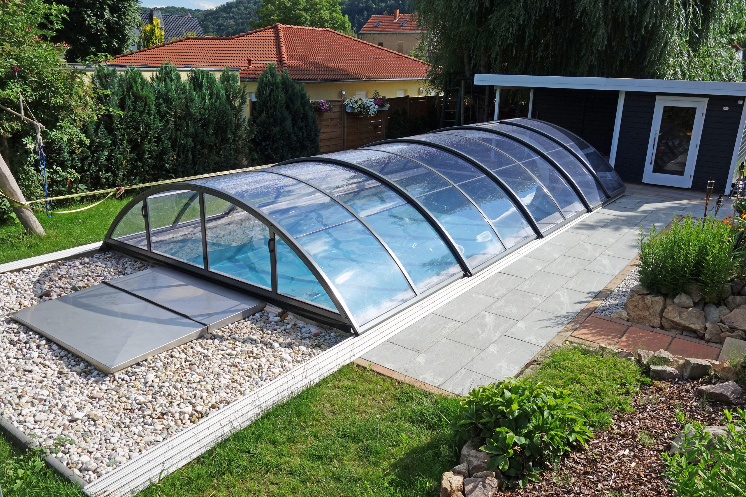 Schwimmbecken 4x8x1,5m mit Ecktreppe, Podest und Überdachung Premium B, im Garten eingebaut