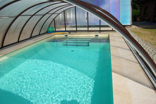 Schwimmbecken 10x4x1,5m mit integrierter Treppe und Podest unter transparenter Poolüberdachung