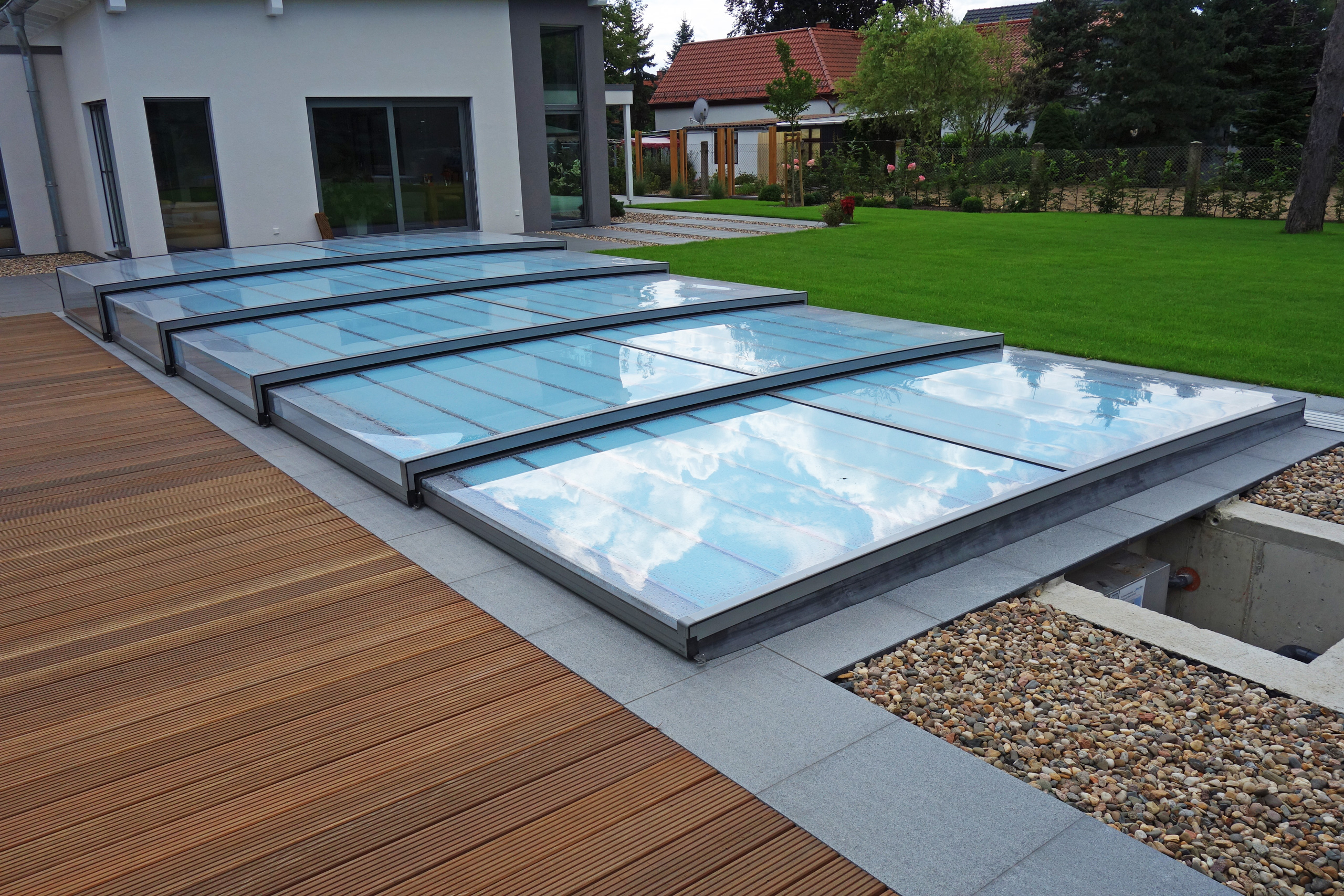 Detailansicht der Poolüberdachung Horizont mit Holzdielen und Kiesbett am Außenpool