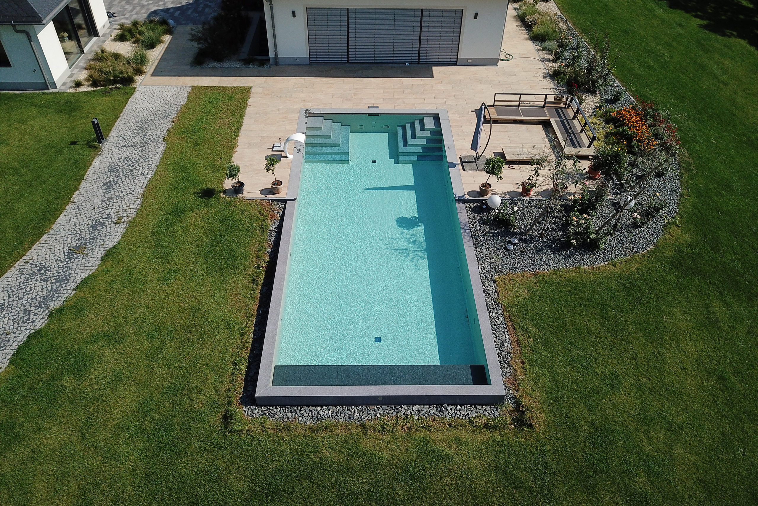 Luftbild Überlaufbecken in Rasenfläche mit Treppe und Terrasse am Haus